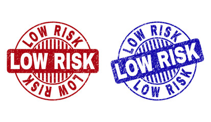 Grunge LOW RISK round stamp seals isolated on a white background. Round seals with grunge texture in red and blue colors. Vector rubber imitation of LOW RISK text inside circle form with stripes.