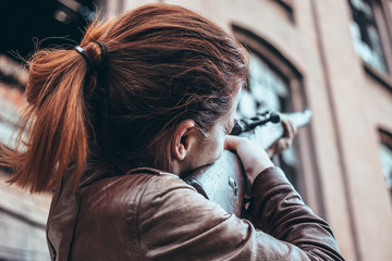 Young woman holding an old rifle
