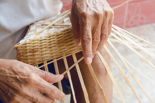 Senior man hands manually weaving bamboo.