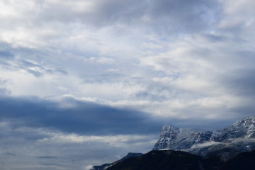 Panorama - dunkle Wolken und verschneite Berge