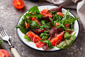 Healthy salad with prosciutto and tomato