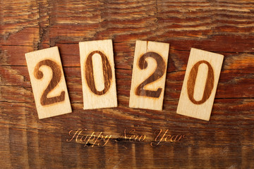 2020 Happy New Year background. scorched numbers on the boards, wooden background. concept