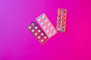 Blister tablets on a neon purple background. Addiction. Top view