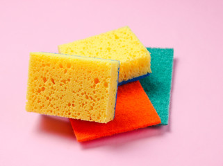 Home and bathroom cleaning kit on pink background. Sponges, abrasives.