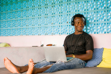 young handsome and happy hipster black African American business man working with laptop computer...