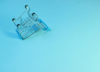 Minimalist shopping concept. Empty inverted miniature shopping trolley, holographic blue light....