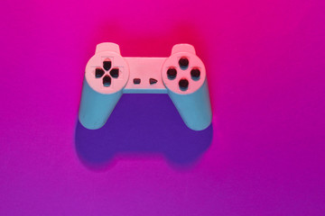 Retro gempad in neon pink light. Minimalism, top view © splitov27