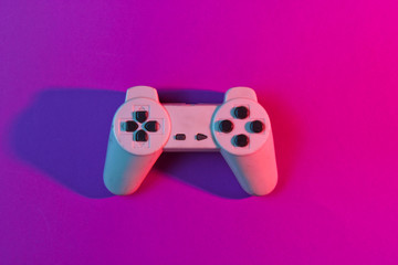 Retro gempad in neon pink light. Minimalism, top view © splitov27