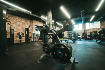 Gym equipment. Dark Gym with barbells on rack. Fitness workout center. Sport concept.