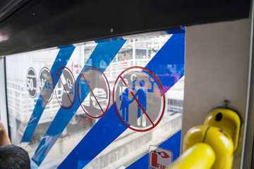 Warning signs on a Transjakarta bus window