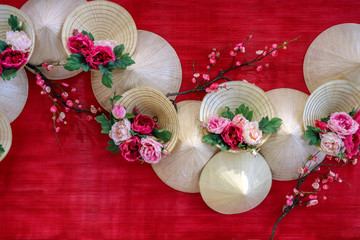 vietnamese cornical hats with flowers in red background