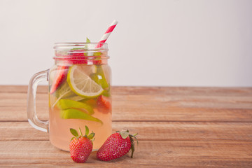 Lemonade or mojito cocktail with lemon, strawberries and mint, cold refreshing drink or beverage with ice.