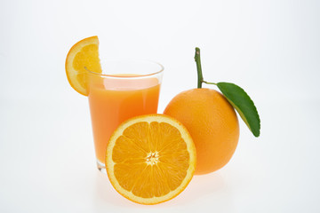Orange juice and oranges with leaves