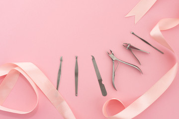 Tools of manicure set for nail care on a pink background with a bow. Beauty concept. Copyspace mockup