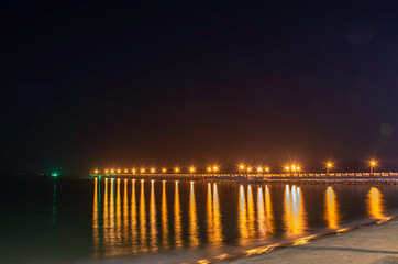 Fototapeta premium The lights on the bridge at night Background Sea at Prachuap Bay in Thailand.