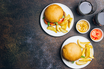An american burger with fried potatoes on the white plate.