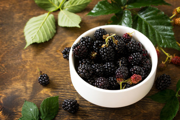 Berries ripe blackberries on kitchen wooden table.