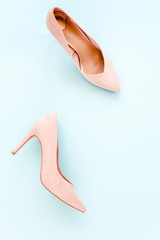 Pastel pink women high heel shoes on blue background. Flat lay, top view trendy fashion feminine background. Beauty blog concept. Fashion blog look. 