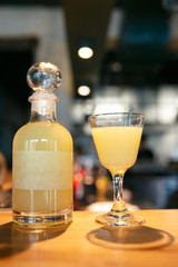 Bottle and glass filled with yellow alcoholic drink on the bar counter. bottle with space for your text