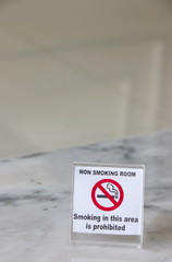 No smoking sign on marble table in hotel room.