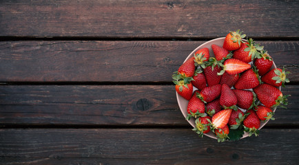 fresh red strawberries on a plate. wooden background