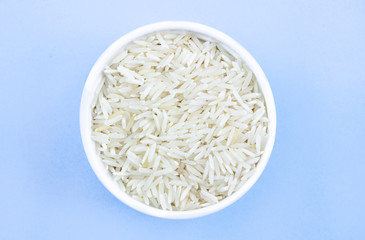 rice in a plate on top, on a blue background, copy space