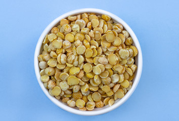 peas in a plate on top, on a blue background, copy space