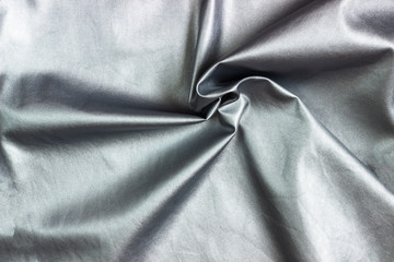 Concept for leather, textile and texture - closeup of crumpled gray silver metallic leather, fabric background