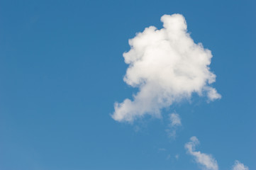 A single white cloud in the blue sky