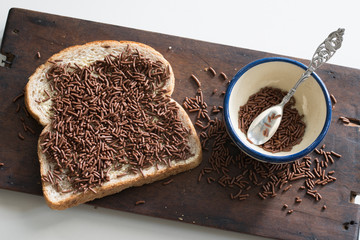 slice of brown bread  with typical Dutch chocolate hail called hagelslag
