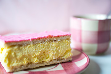 traditional Dutch sweet pastry tompouce, waffle with pudding and pink frosting, Cup of coffee, against pink background
