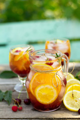 Homemade refreshing drink. Wine sangria or punch with fruits in glasses, cocktails with fresh fruits, berries and rosemary on a wooden rustic table. Copy space.