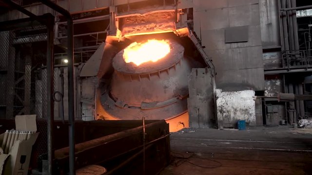 Metallurgical shop with big vat and molten steel inside, heavy industry concept. Stock footage. Hot steel vat at the metallurgical plant.