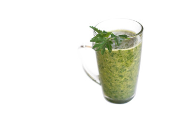 Green fruit and vegetable smoothie with a sprig of parsley in a transparent glass mug on a white background. healthy diet. food high in vitamins