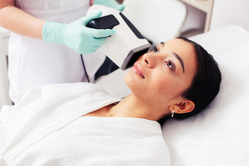 Woman lying on the pillow and having her skin diagnosed