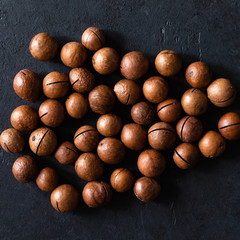 Top view of background texture of fresh natural unshelled raw macadamia nuts, full frame and flat lay