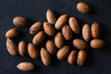 Natural pecan background pattern texture in-shell nuts, backdrop Pecans in shell top view