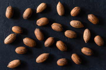 Natural pecan background pattern texture in-shell nuts, backdrop Pecans in shell top view