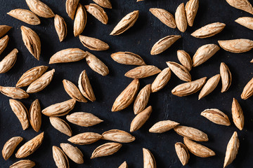 Top view of Background of raw peeled almonds on black table