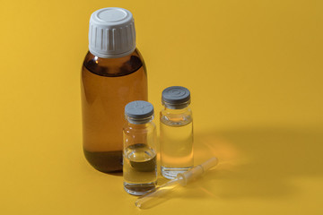 Medicine bottles and pipette on a yellow background. Medicines for individual preparation. Drip medicine. Dropper glass. Bottle Mock-Up