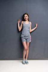 fitness woman. Young sporty Caucasian female model isolated on gray background in full body.