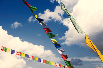 Traditional buddhist tibetan prayer flags against a blue sky