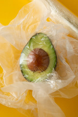 Close up green Avocado in plastic bag for sale or fridge. Effect Destroyer of the use of plastic...