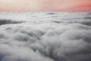 View from plane window. Colorful sunset with white cumulus clouds