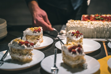 Strawberry and cream birthday cake served by the waiter in ceramic dishes