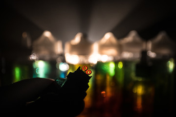 Vape concept. Electronic Cigarette vape explosion. Smoke clouds and vape liquid bottles on dark...