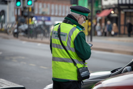 civil enforcement officer or traffic warden with glasses in typical English town