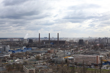 Fototapeta premium The aerial View of urban fringes in a cloudy day.View over the city rooftops at industrial suburb.Heating Power Plant,moderns buildings,uptown/Industrial cityscape