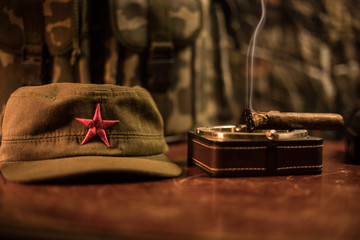 Close up of a Cuban cigar and ashtray on the wooden table. Communist dictator commander table in...
