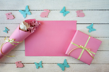 Różowo - białe wiosenne tło z zajączkami, motylkami, kwiatami i pudełkiem przewiązanym wstążką - obrazy, fototapety, plakaty